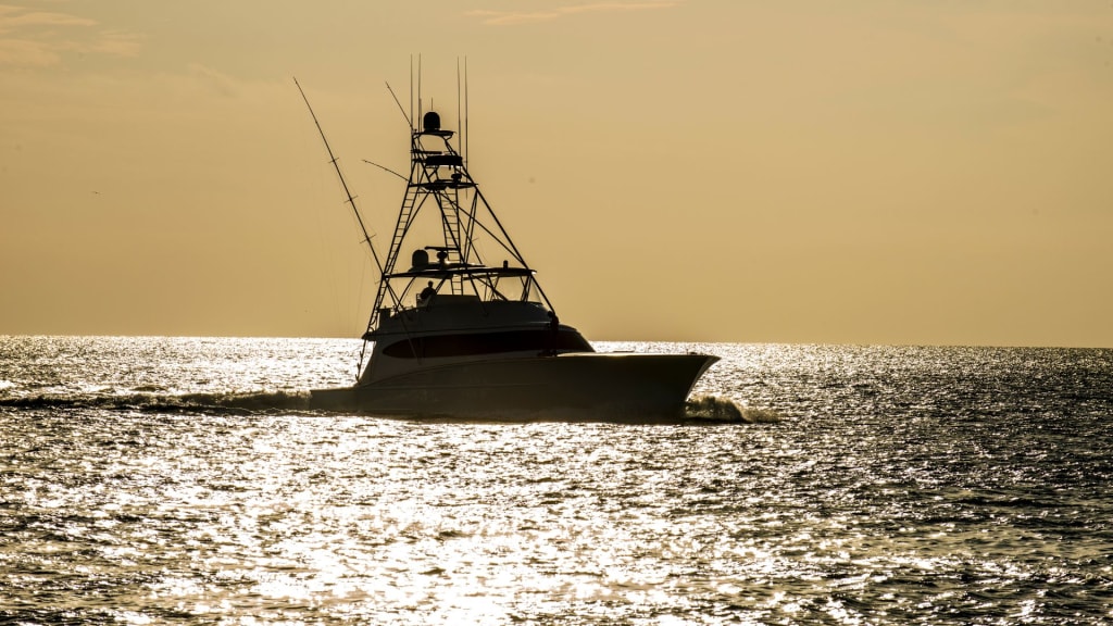 A boat with tall antennas cruises over the water at sunset, crafting a stunning silhouette against the sunlit sea—a perfect scene for those enjoying a fishing charter in Playa del Coco.